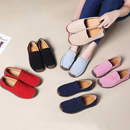 Casual women’s loafers in various colors including black, red, blue, pink, and beige, displayed on a light floor.